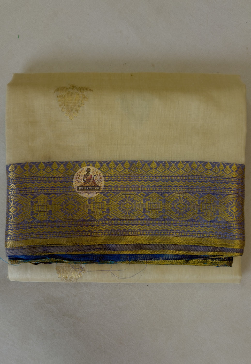 Flat lay of handwoven Tussar silk slub saree from Jharkhand showing natural earthy gold body, traditional border and wild silk texture detail — Dakshin Vastram