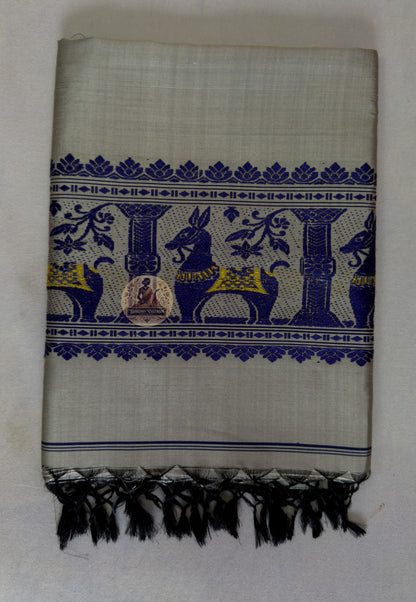 Full flat lay of handwoven Baluchari silk stole in stone grey – complete view of buti body, royal blue court narrative border and black silk tassel fringe, Bishnupur Bengal weave