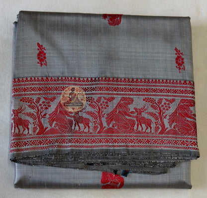 Traditional handloom Baluchari saree in dusk blue with hand-woven narrative motifs and warm gold contrast pallu